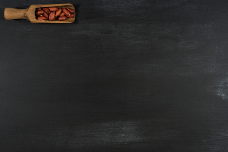 Peanuts in a scoop on a black chalkboard. Top view.の写真素材