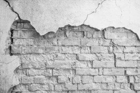 Old wall of bricks with chapped plasterwork. Abstract background with empty space for your design. の写真素材