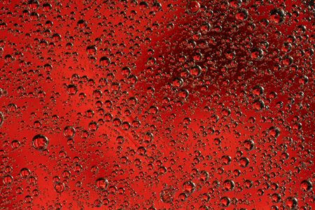 Abstract red background with oil circles . Bubbles of water close up . Oil bubbles in the water...