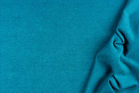 Bright blue fabric texture with folds. Blue fabric background with pleats.