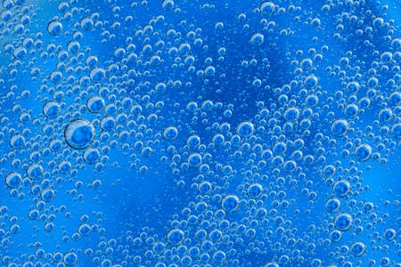 Large beautiful Oxygen bubbles underwater on a blue background macro. Movement oxygen bubbles in a...