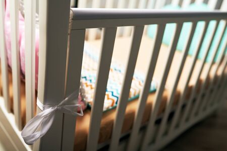 A can on white baby crib with a brown pink pillow and brown mattress. A gentle bed for the baby. subject photoの写真素材