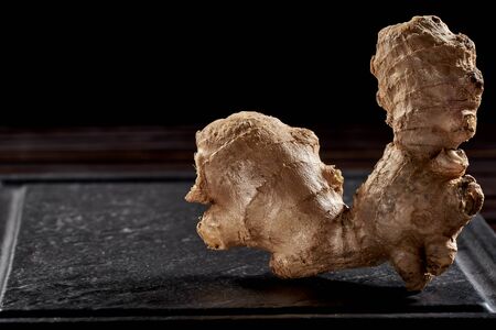 Ginger root on a black background. side view. volume ripe product. macro photo. Against viruses and diseases. studio photoの写真素材