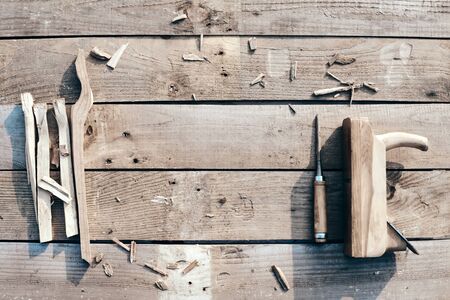 wooden background. On the village table lie tools, jointer, wood cutter, dents, sawdust. Wood thread...