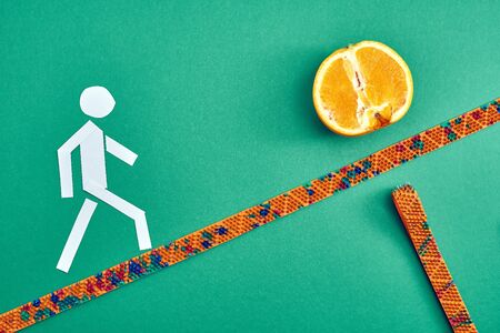 A white paper man walks along a masseur to an orange. top view. healthy lifestyle. Subject and promotional photography. For relaxation and health.の写真素材