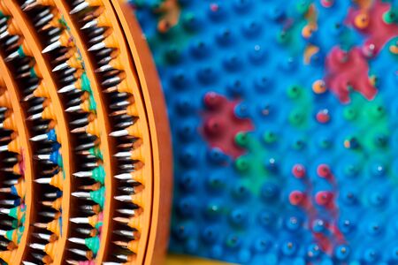 Composite frame with twisted orange massager tape with metal spikes, needles. Macro photo. Advertising, thematic and subject shooting. For relaxation and health.の写真素材