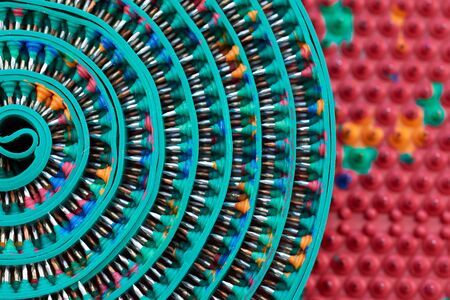 Composite frame with twisted green massager tape with metal spikes, needles. Macro photo....