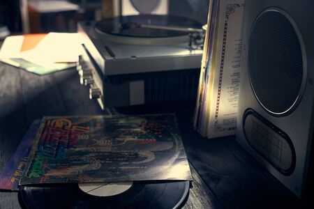 The vinyl disc lies on a table near the vinyl player, amplifier and acoustics. Old school turntable. art project. musical atmosphere. Old player and analog music. subject photo.の写真素材