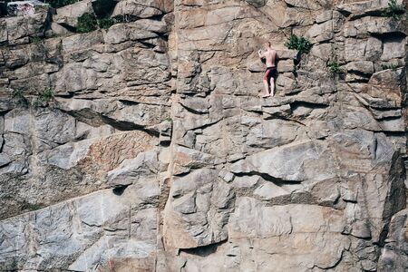 Guy's climbing rocks, extreme. Crested surface, in cracks. Rock. Stone walls fearless personの写真素材