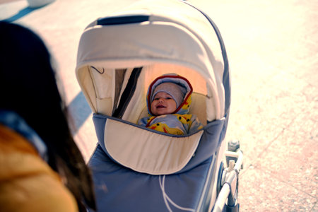 A smiling child in a stroller on the street to the park. outdoor leisure. Sunny weather. Healthy lifestyleの写真素材