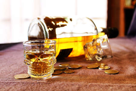 skull whiskey glass and coins.の写真素材