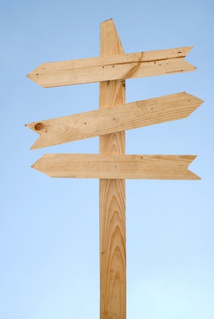Blank wooden direction signpost against a blue sky の写真素材