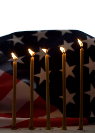 Lighted candle with an old American flagの写真素材