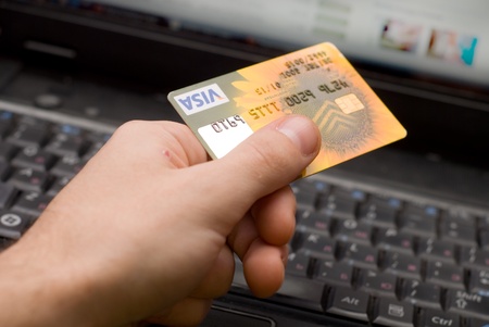 credit card in hand for purchases are in the internetのeditorial素材