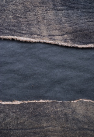 Torn leather over a black backgroundの写真素材