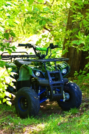 camouflage ATV 125 cc  parked in forest