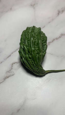 Bitter melon, Bitter gourd isolated on tiles background. Green Vegetables