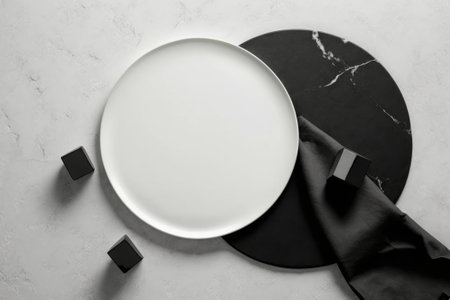 Empty white plate with black and white napkinle background.の素材