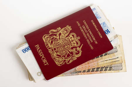 British Passport with foreign currency on a white backgrondの写真素材