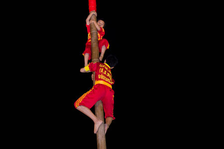 Acrobats are climbing a wooden post and risk their lifes at a very dangeous position on February 12,...