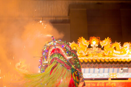 Acrobats are performing a lion and dragon dance with a well trained skill, danger but very exciting on February 12, 2014 in Yala, Thailand.のeditorial素材
