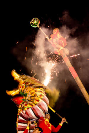 Acrobats are performing a lion and dragon dance with a well trained skill, danger but very exciting on February 12, 2014 in Yala, Thailand.のeditorial素材
