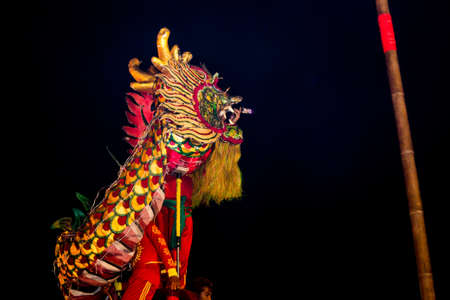 Acrobats are performing a lion and dragon dance with a well trained skill, danger but very exciting on February 12, 2014 in Yala, Thailand.のeditorial素材