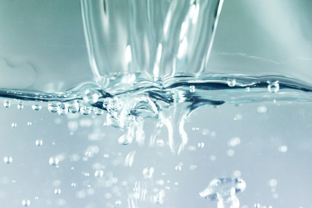 A stop motion of water drops dribbling onto the surface.の写真素材