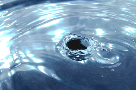 A stop motion of water drops dribbling onto the surface.の写真素材