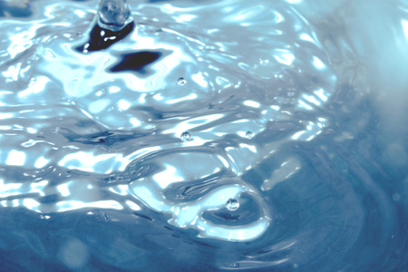 A stop motion of water drops dribbling onto the surface.