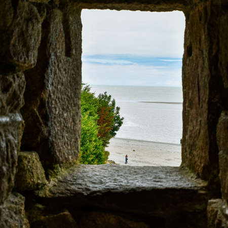 Looking at the sea and the blue sky through a stone window. Sensation of hope.
