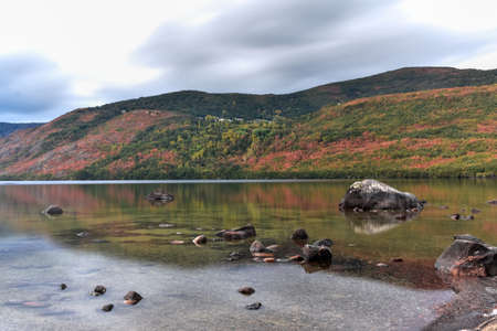 Mountain landscape with a lake and reflected mountains and forest in autumn. Sanabria Lake, Zamora, Spainの写真素材