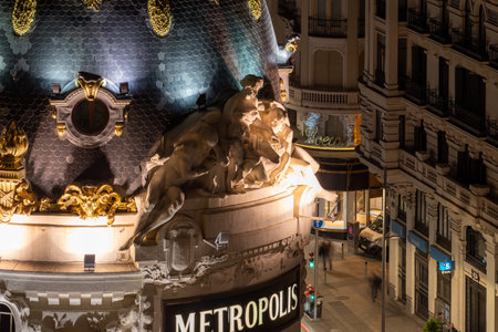 MADRID, SPAIN - APRIL 13, 2019: Detail of the Metropolis building dome, whose statues seem to point a finger at the passers-by walking along Madrid's famous Gran Via street.のeditorial素材