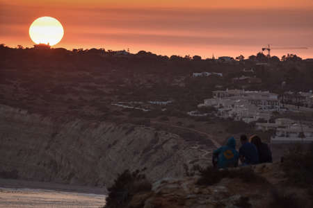 People enjoying a Beautiful sunset over the cliffs of the beach. Concept of tourism and travel. Algarve, Portugalの写真素材