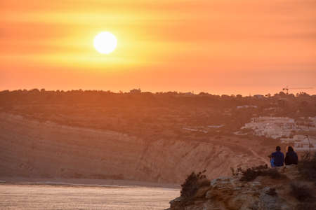 Unrecognizable couple enjoying a romantic sunset. Romantic and love concept. Algarve, Portugalの写真素材