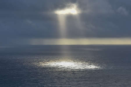 Rays of light that pass over the clouds and illuminate the sea like spotlights. Concept of nature...
