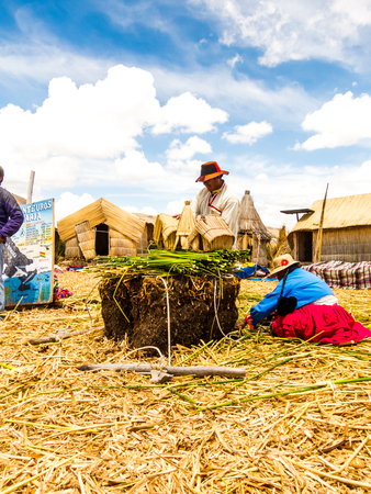 Puno, Peru - December 10, 2011: Two Uros working on Reedのeditorial素材