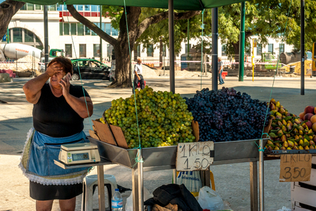 Lisbon, Portugal - Septmember 19, 2016: Old woman selling grapes in front of Cais do Sodre stationのeditorial素材