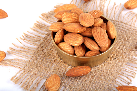 Almonds in bowl on wooden background, group of almonds, sackclothの写真素材