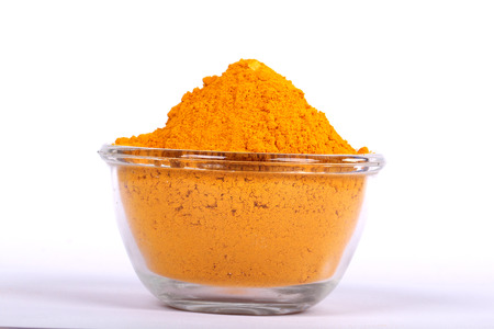 turmeric powder with fresh turmeric root in whiteの写真素材