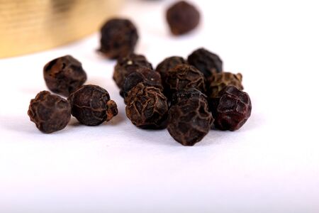 Close-up of peppercorns on white background.