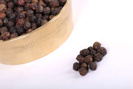 Close-up of peppercorns on white background.