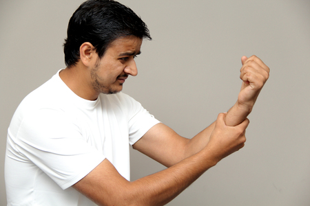 joint pain, pain in arm, expressions of young amazed man isolated on gray backgroundの写真素材