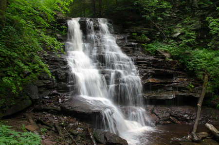waterfall flowing over rocks in a parkの写真素材