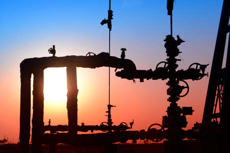 Oil pipeline features, under the sunset of oilfieldの写真素材