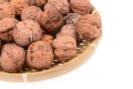 A basket of walnuts on a white background