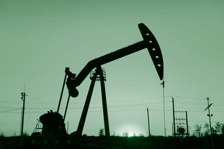 Is operation of the pumping unit in oilfield sunset, close-upの写真素材