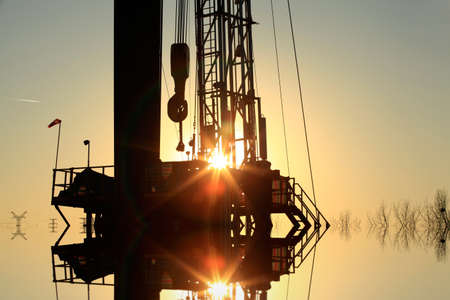 The oil derrick, under the setting sunの写真素材