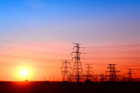 High voltage towers under the setting sun