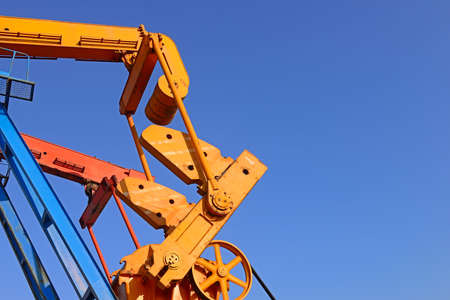 The beam pumping unit is working against the blue sky